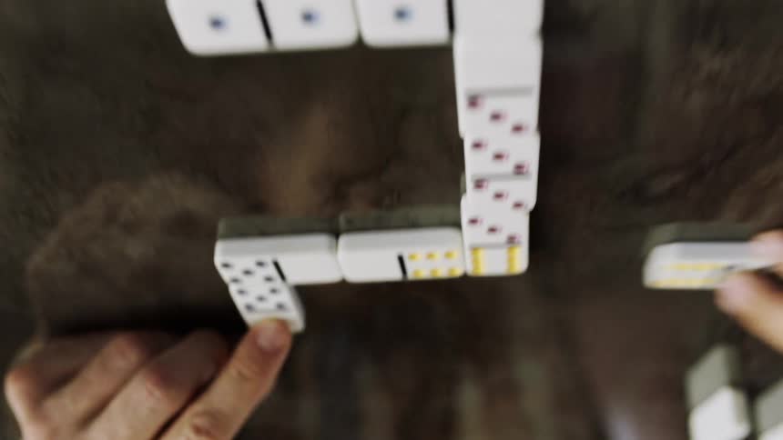 Dominoes are being slid across the surface