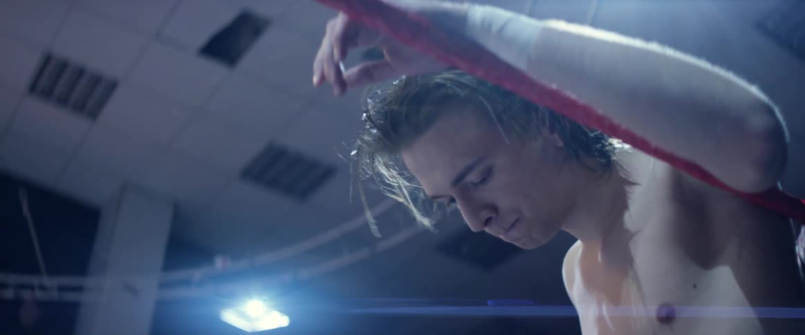 A wrestler is tapping the ropes of a ring