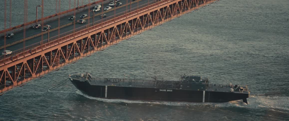 A large barge passes under a bridge