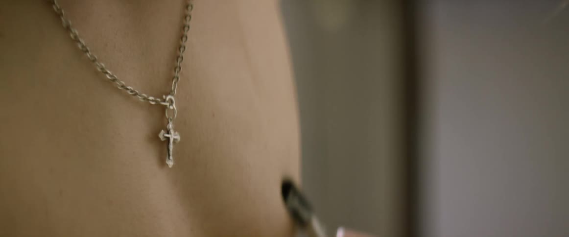 Man wearing a necklace paints chest