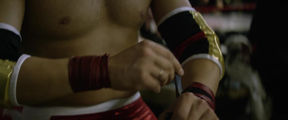 A man in studded glasses wraps tape around his hands