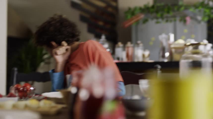 Two friends enjoy food and laughter together at a dining table