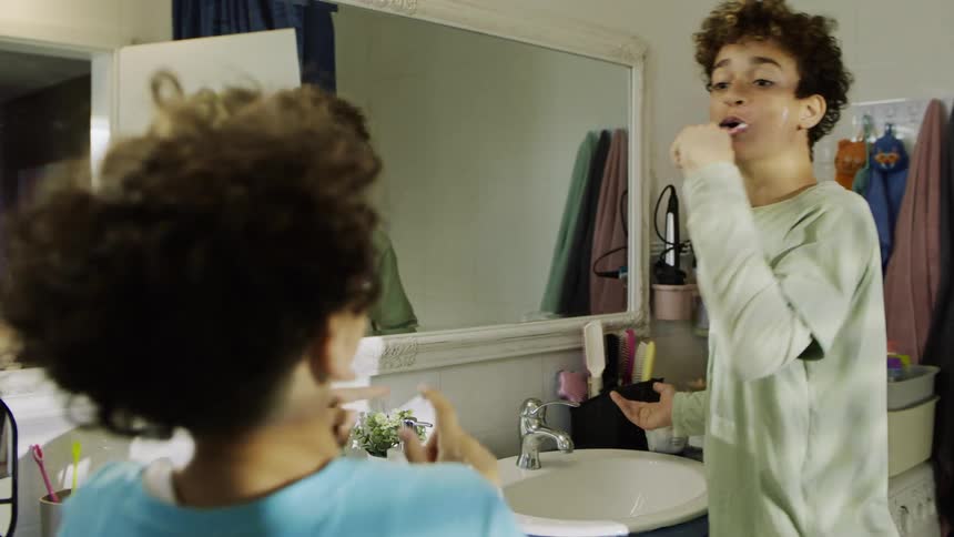 Two boys brushing their teeth in the bathroom