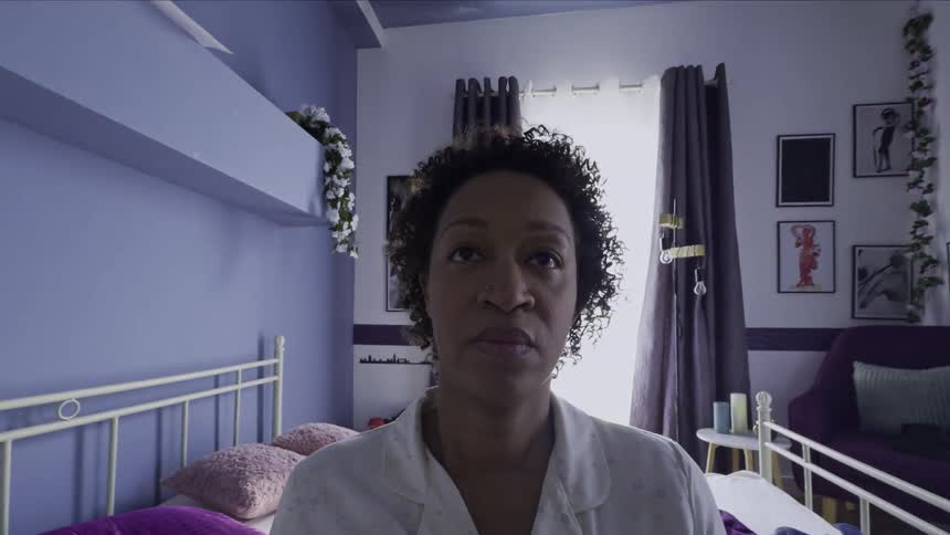 A woman stood from the bed at daytime and walked out of the bedroom