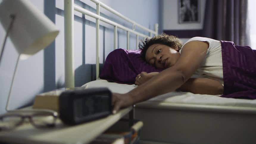 A woman wakes up to an alarm system beside her bed