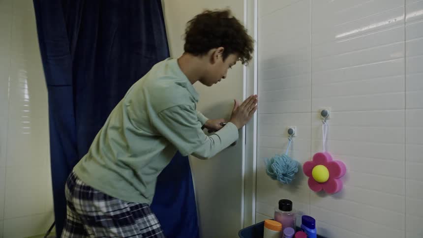 Two brothers play around by the bathroom door