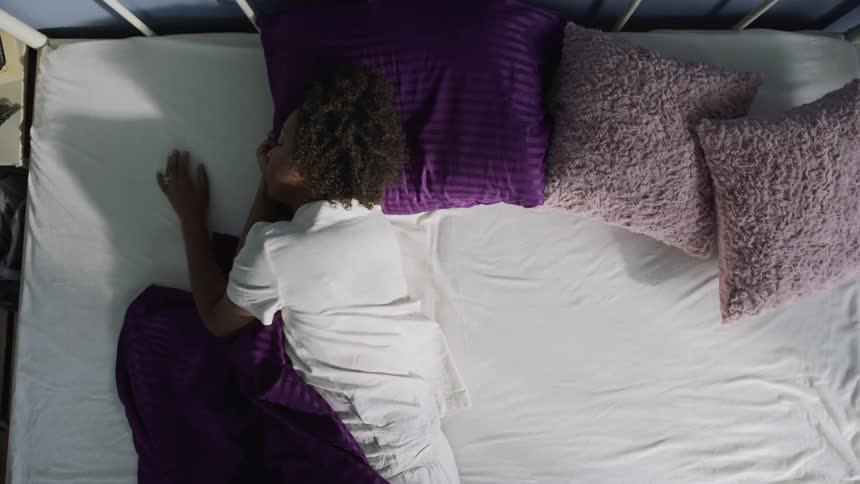 A woman lies awake in bed struggling to sleep