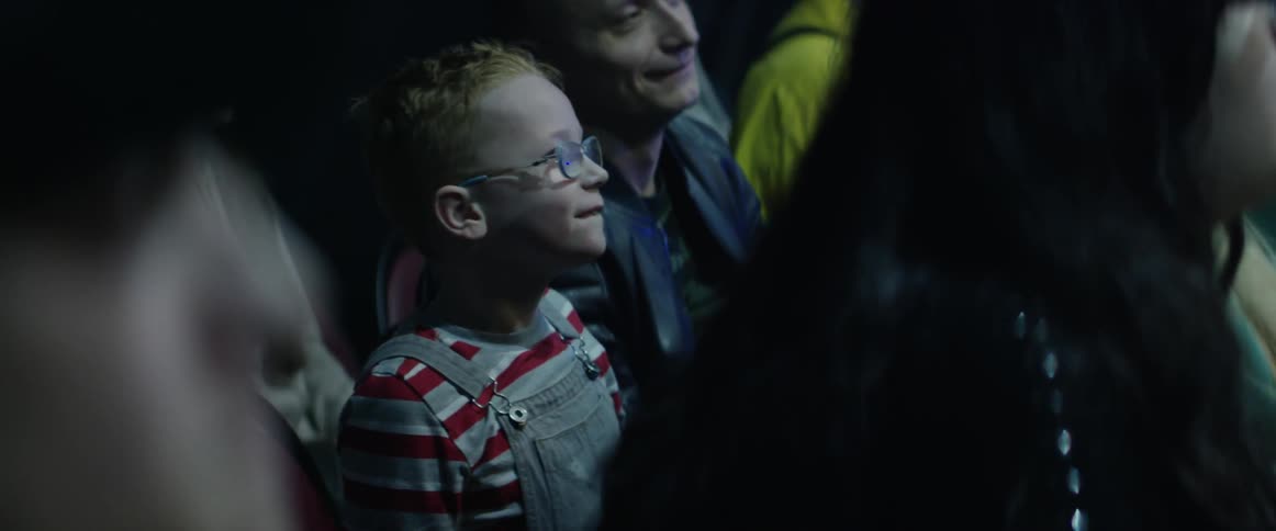 A little boy gets excited and claps in a crowd