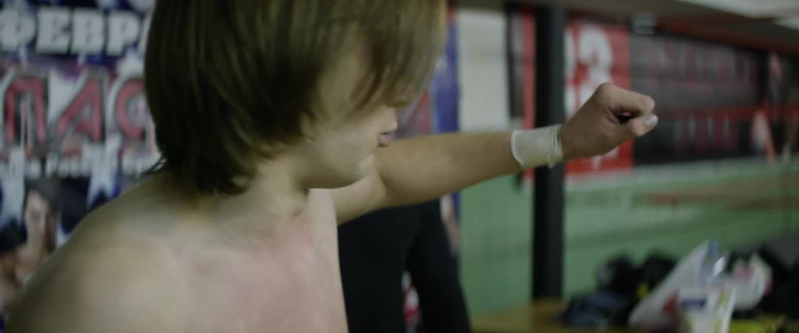 Wrestlers stand outside of a ring talking