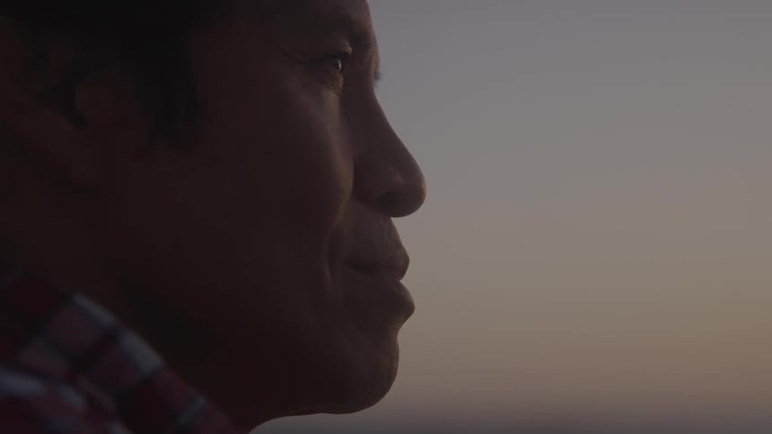 Man standing outdoors after dusk stares