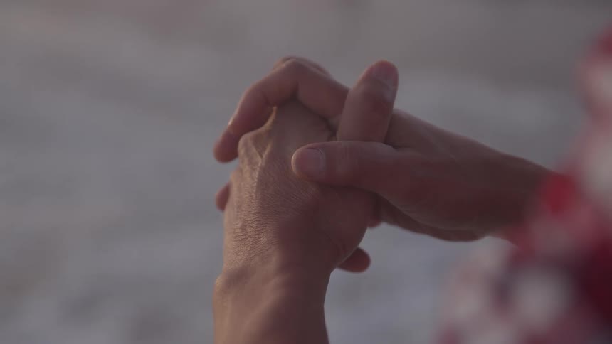 The man has his hands clasped together