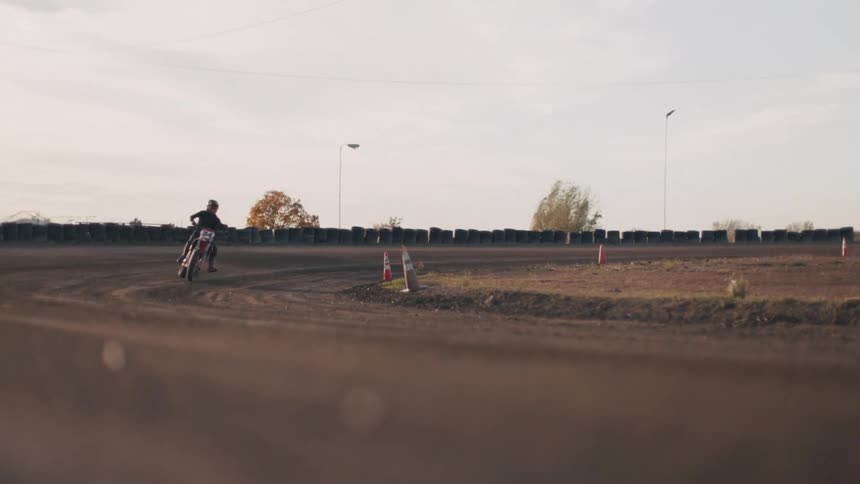 Motorcyclist takes a sharp turn on a dirt race track
