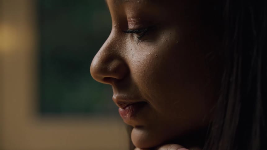 Woman with hand on face with thoughtful expression