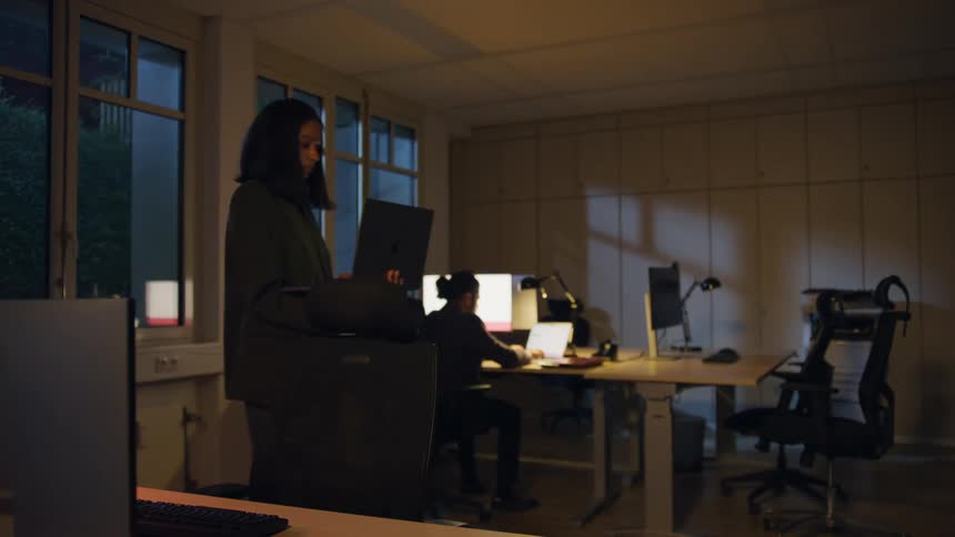 The woman paces in the office with a laptop