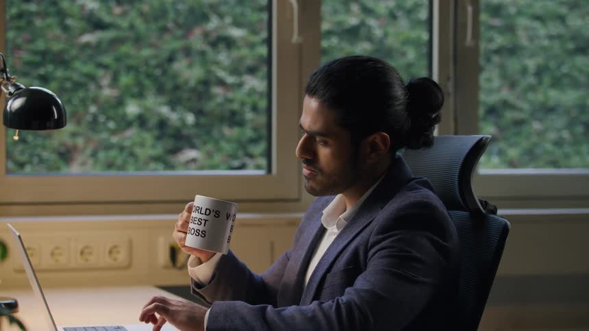 Man works on a laptop at a modern office desk