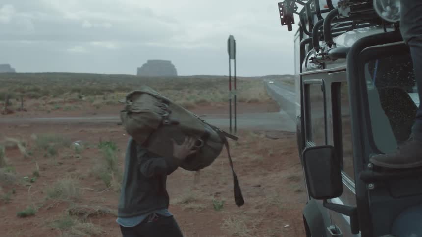 Backpack is tossed from the roof of a vehicle