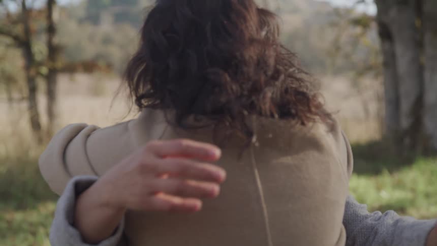 Woman outdoors hugging an elderly lady