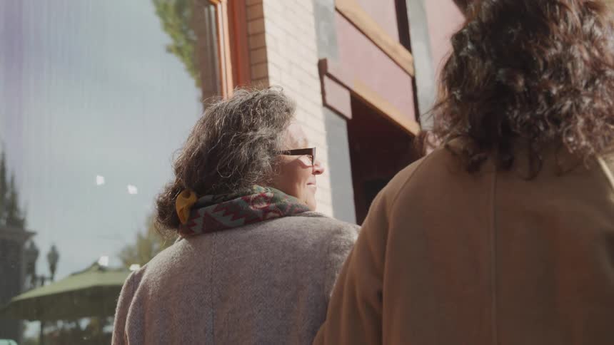 Two women are walking past the building