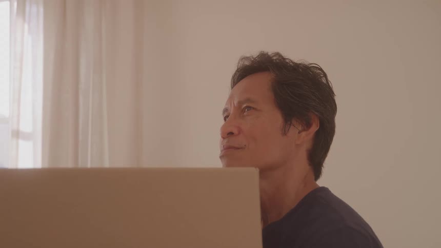 Man in an indoor space looking around while holding a box