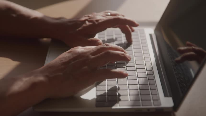 The man is typing on his laptop