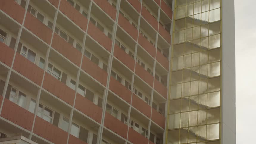 A multistory residential building is seen around midday