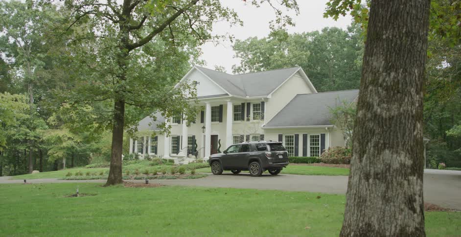 Large suburban home with a parked suv in the driveway