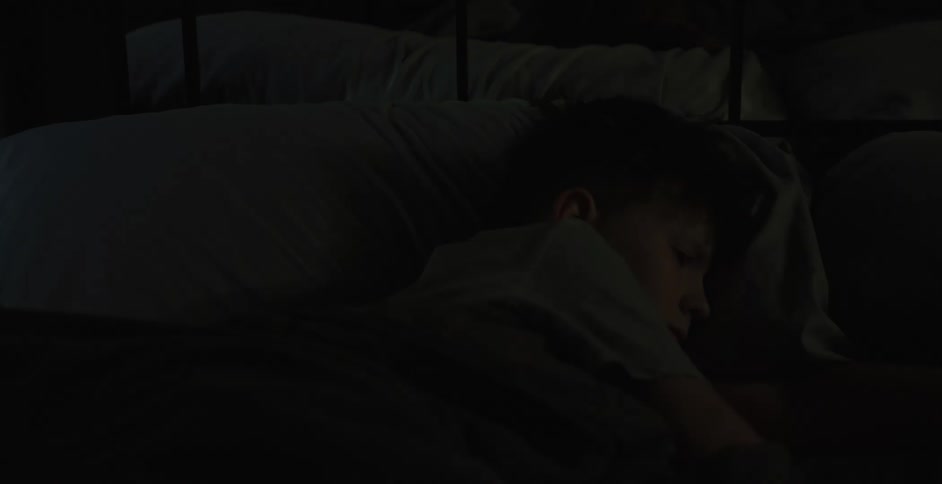 Sleeping boy waking up and getting up