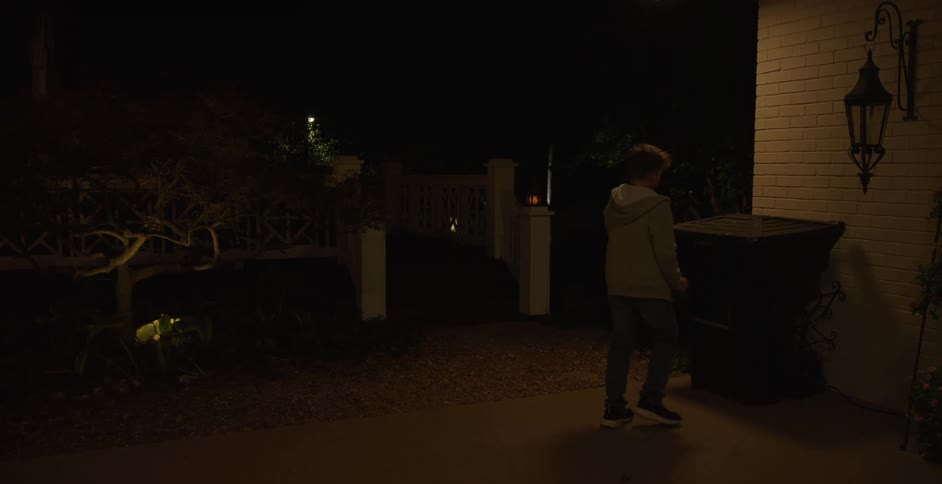 Man going to throw out the trash at night