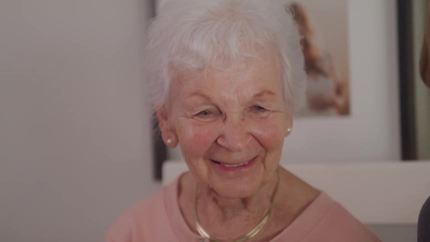 The woman is smiling as she looks at photos
