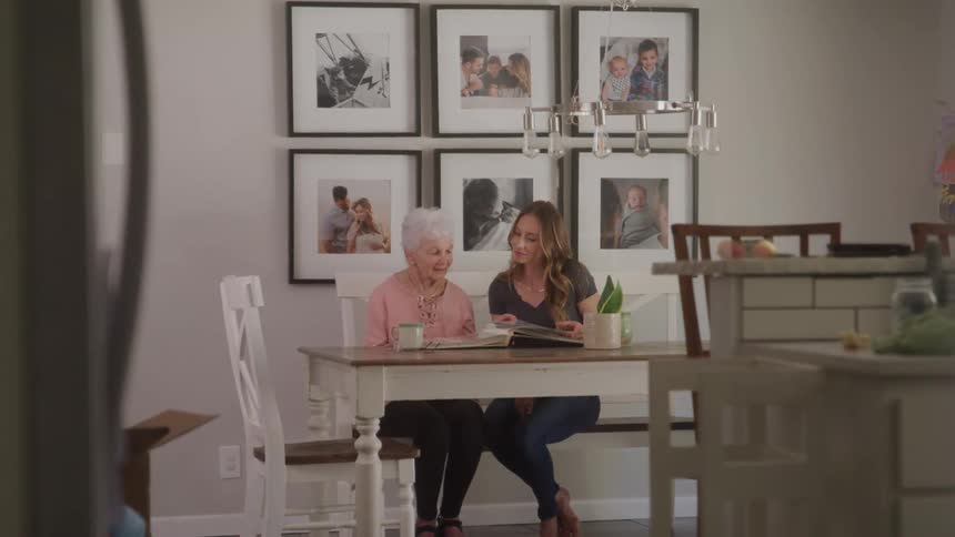 Grandmother and granddaughter share a warm moment over a family photo album