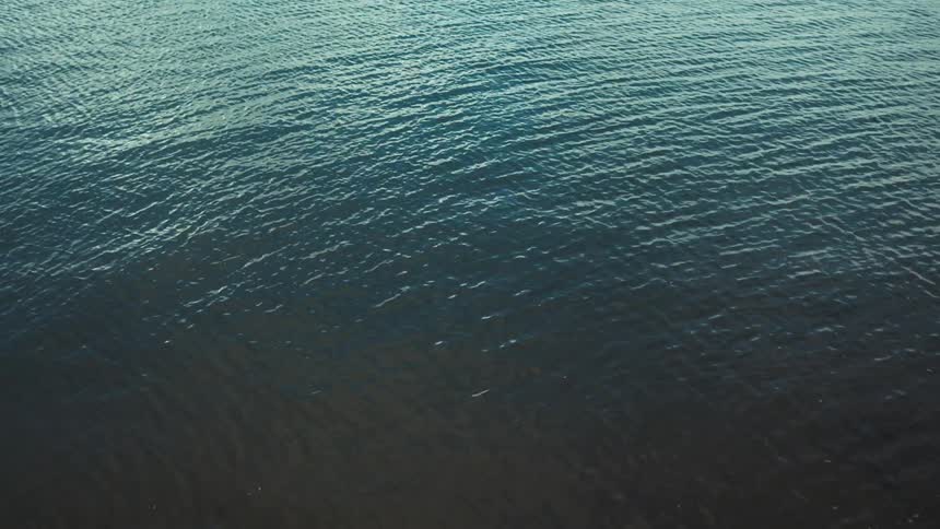 Small ocean waves appear to ripple across the surface of the water during the daytime