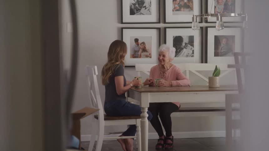 Young woman sitting talking to an elderly lady at a table
