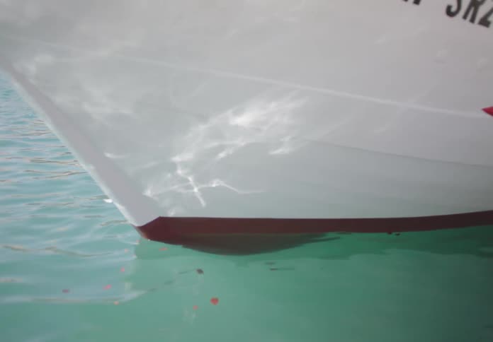 A boat floats on the ocean around midday