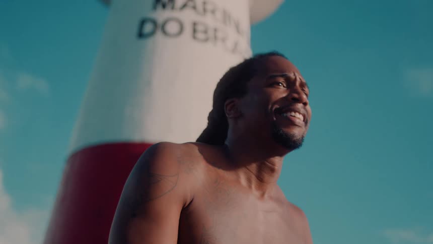 A shirtless man is playing music outside
