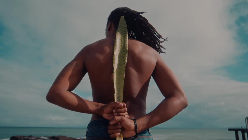 A man is holding a stick on the beach