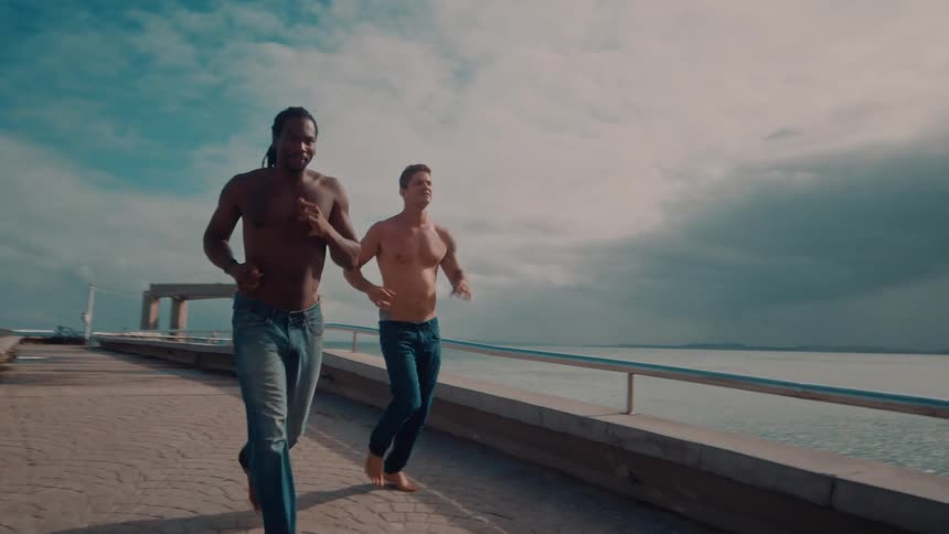 Two men are running on the pier over the water