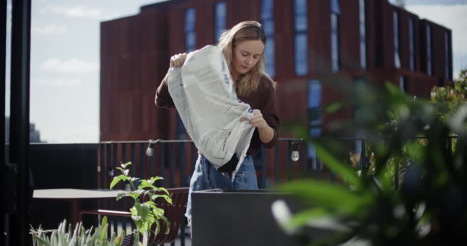 A woman is pouring a bag of dirt in the garden