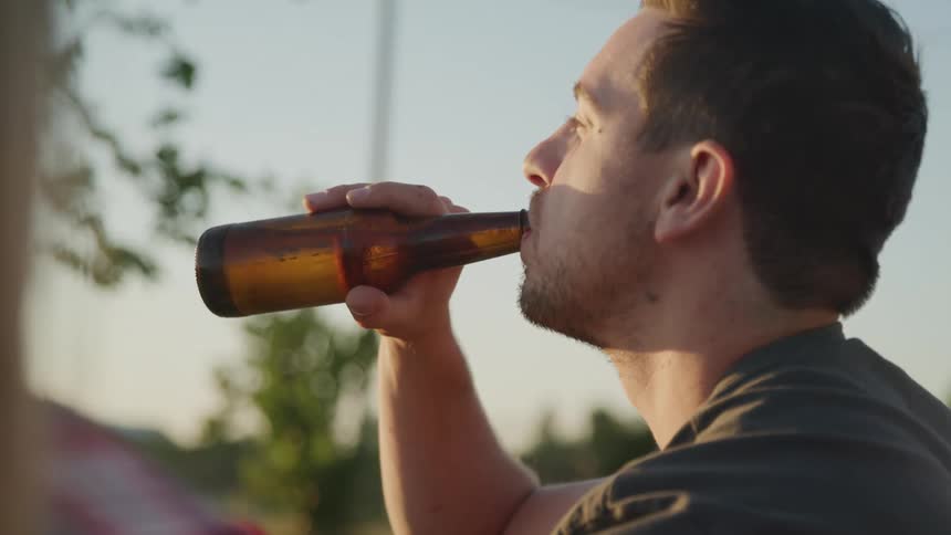 A man drinking from a beer bottle