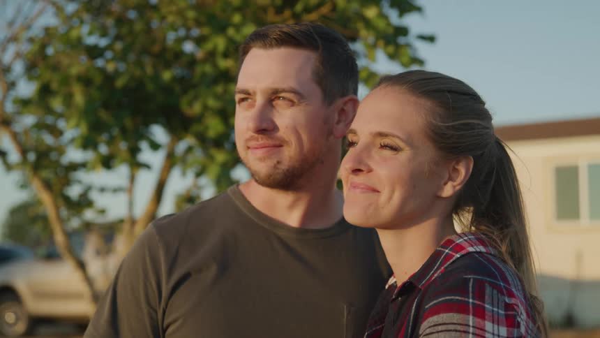 Close portrait of a young couple smiling while standing outdoors during daytime