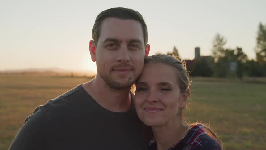 Close up portrait of a young caucasian couple standing together outdoors at sunset