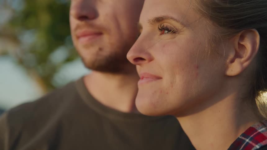 Portrait of a woman standing next to a man outdoors with happy expression