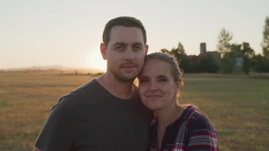 Couple hugging together in a field