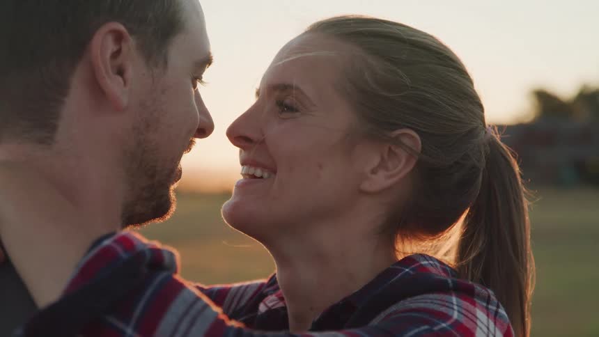 A couple shares a joyful intimate moment outdoors at sunset