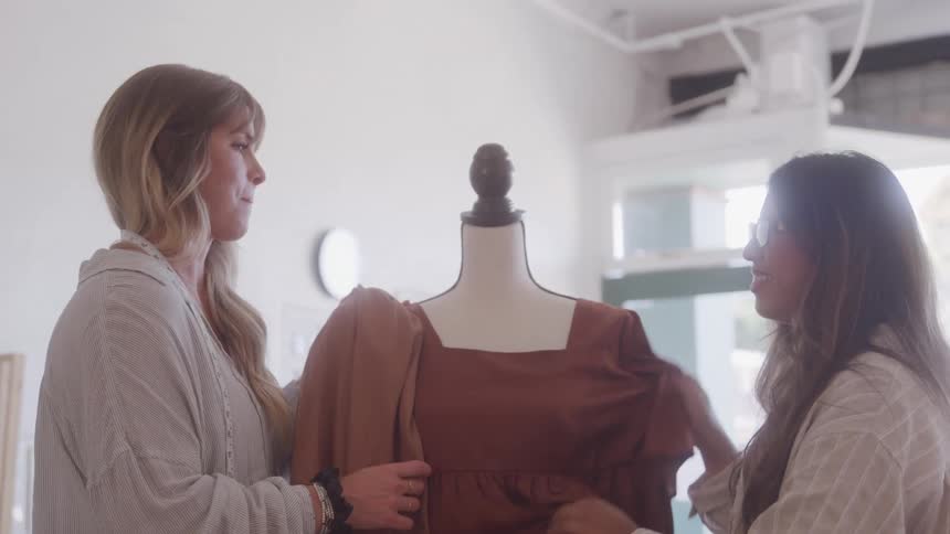 Two women talking with a mannequin in the middle
