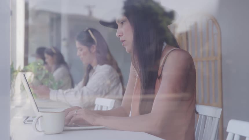 Group of women sitting at a table working on laptop