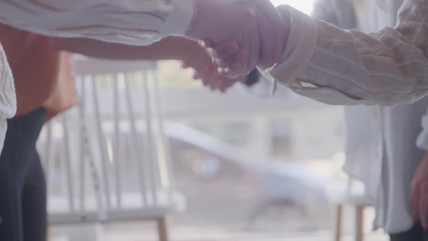 People shaking hands indoors in a closeup shot
