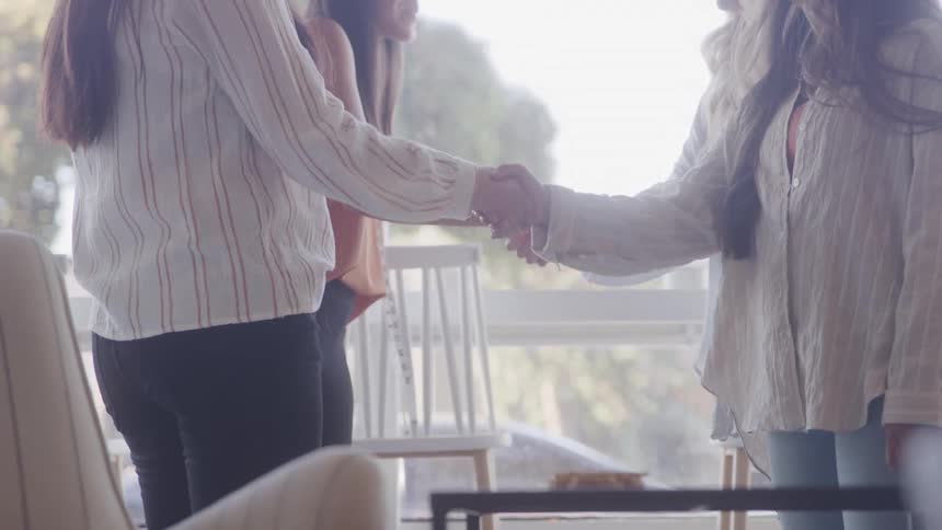 Four women greeting each other with their hands