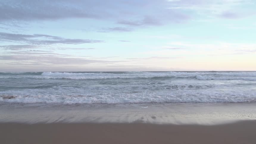 Ocean waves wash up onto a sandy beach