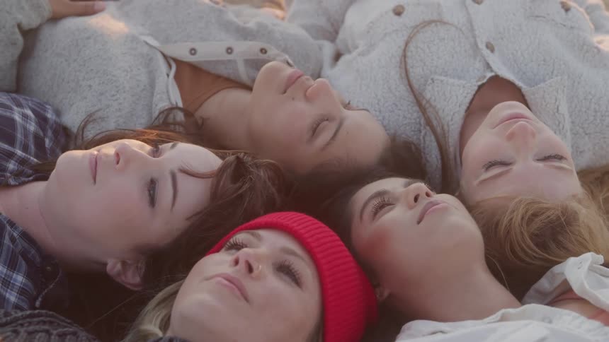 Portrait of five women lying together in an outdoor setting