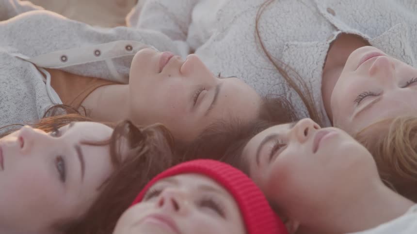 Friends are laying down together in a circle